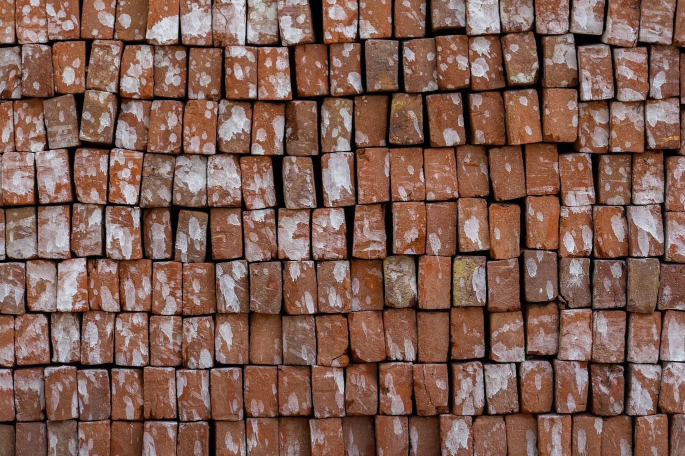 Pilhas de tijolos cerâmicos vermelhos empilhados no pátio